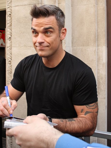 Robbie Williams signs autographs for fans