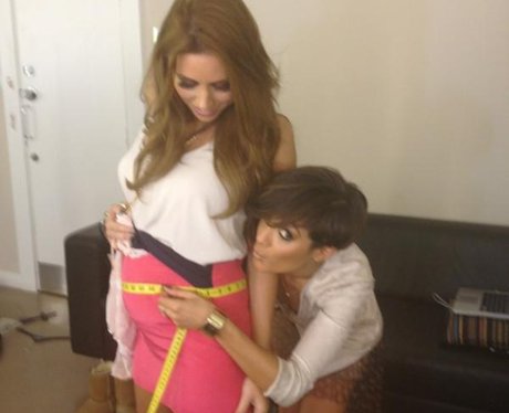 Frankie Sandford measures Una Healey's baby bump with a measuring tape