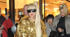 Lady Gaga dressed in  gold outfit