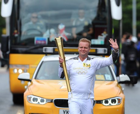 Smiles all round as torchbearer waves at the crowd