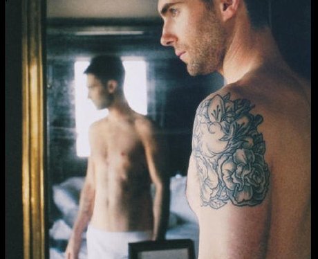 Adam Levine looking at himself in a mirror