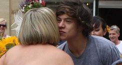 Harry Styles kisses a newylwed on the cheek.