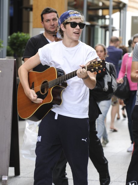 One Direction's Niall Horan playing the guitar.