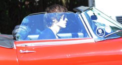 Harry Styles in a red sports car