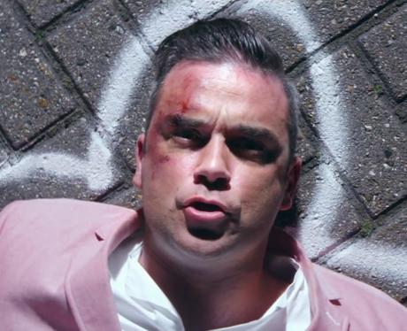 Robbie Williams wearing pink suit in Candy video