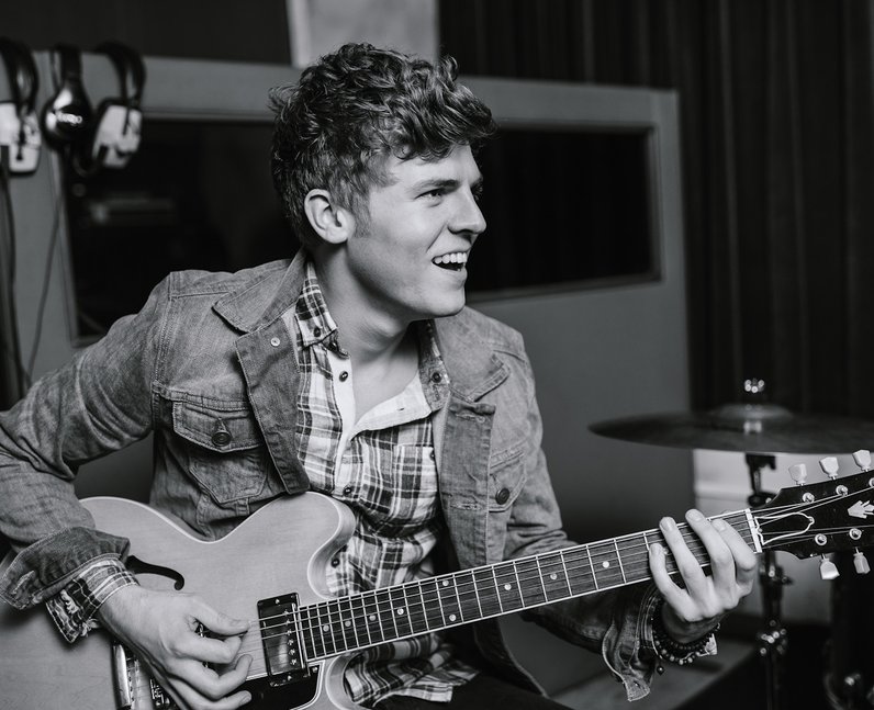 Lawson's Joel Peat playing a guitar