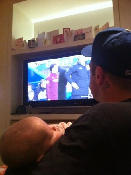 Robbie Williams watching the tv with his baby