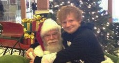 Ed Sheeran sitting on Santas's lap