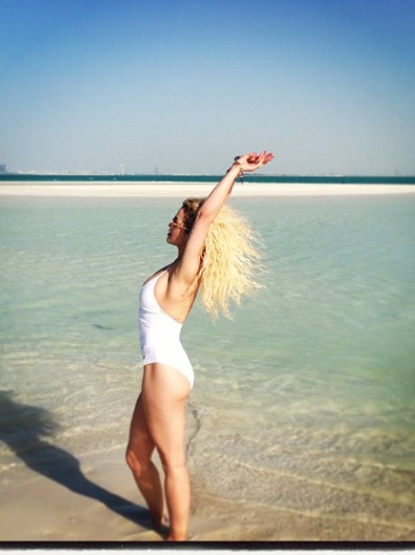 Rita ora poses on a beach in white bikini