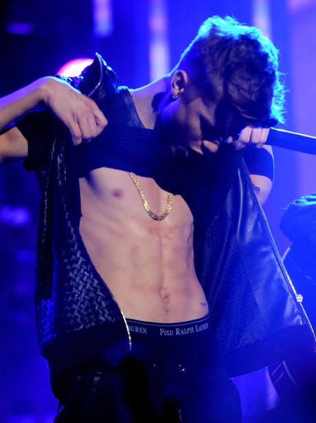 Justin Bieber flashes his abs on stage
