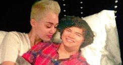 Miley Cyrus in bed with a Harry Styles cut out