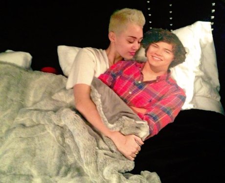 Miley Cyrus in bed with a Harry Styles cut out