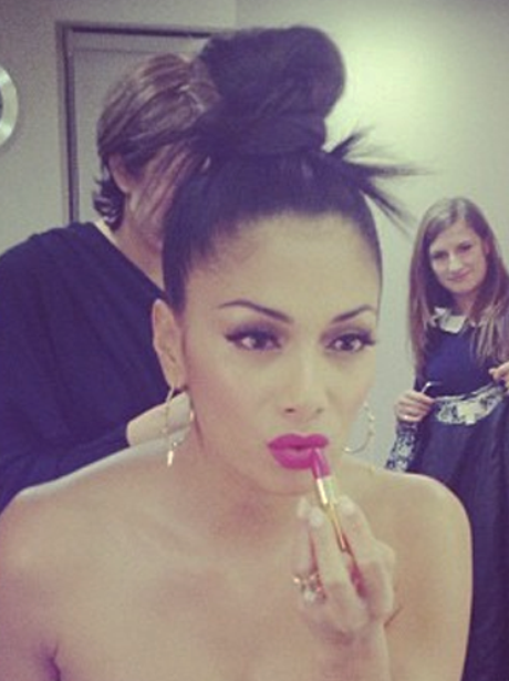 Nicole Scherzinger applies some lipstick in the mirror