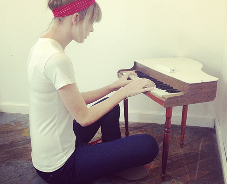 Taylor Swift playing a small piano