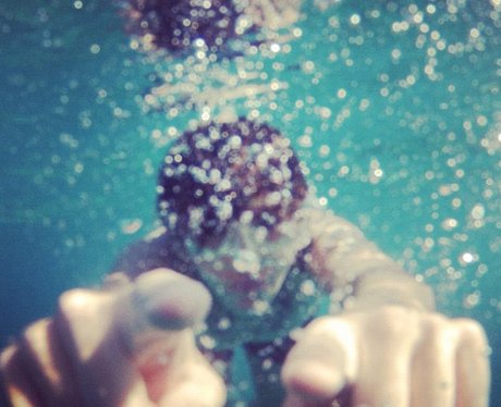 Harry Styles tweets a picture of him swimming on holiday