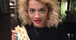 Rita Ora holding a sandwich