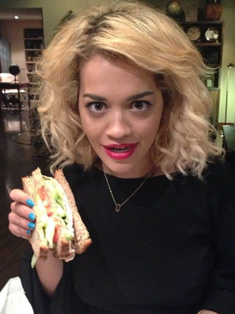 Rita Ora holding a sandwich