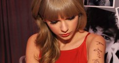  Taylor Swift writes lyrics on her arm backstage 