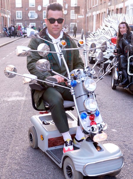 Robbie Williams sitting on a custom mobility scooter.