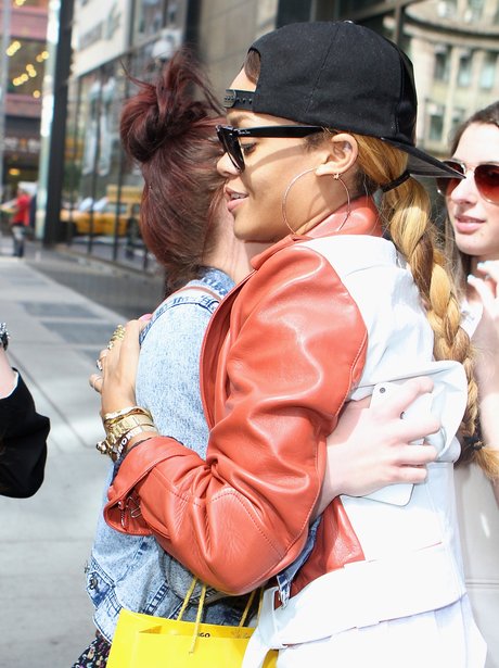 Rihanna hugging a fan in a black baseball cap