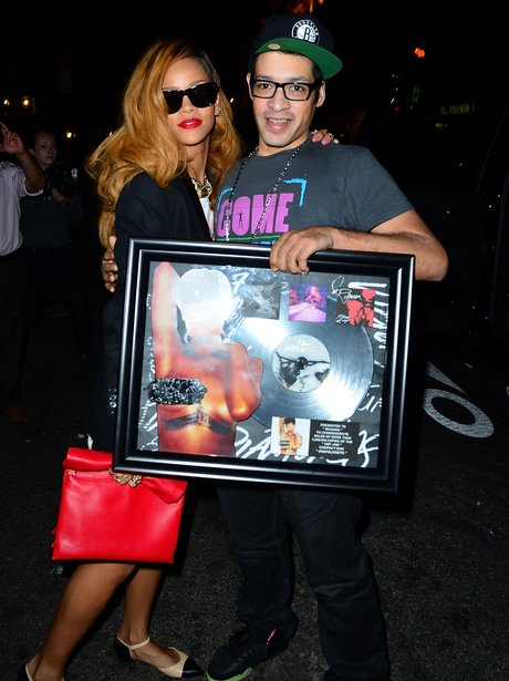 Rihanna posing with a fan and a picture