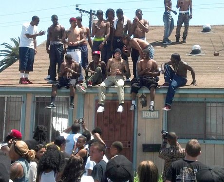 Chris Brown sitting on a roof filming Aaliyah video