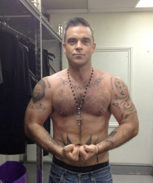 Robbie Williams reveals bizarre tattoo of his FACE on his own chest in  shocking topless shot - OK! Magazine