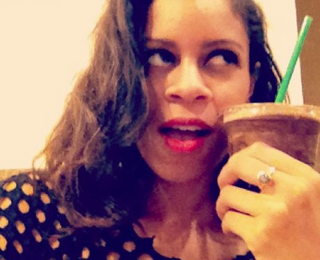 AlunaGeorge holding a Frappe against her cheek