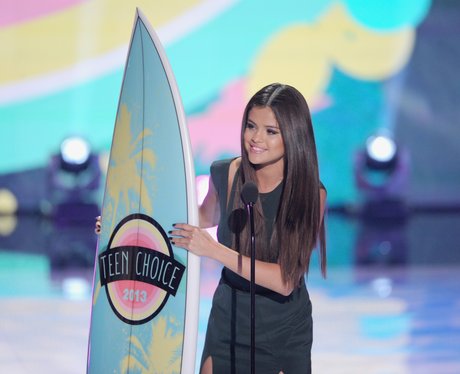 Selena Gomez holding Teen Choice Award surfboard in 2013