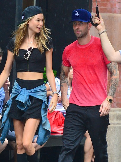 Adam Levine and Behati Prinsloo under an umbrella
