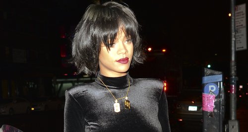 Rihanna wearing a black body suit 