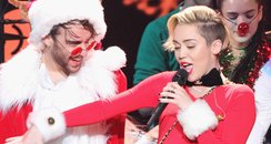 Miley Cyrus on stage with santa