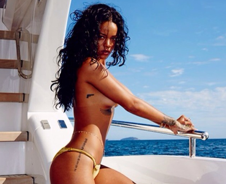 Rihanna posing topless in a bikini