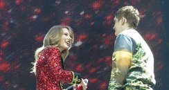A fan joins Taylor Swift on stage