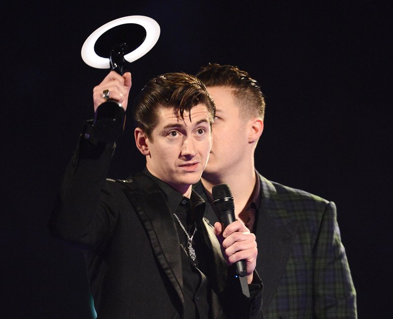 Arctic Monkeys singer Alex Turner holds up the band's award for British at the... - Capital
