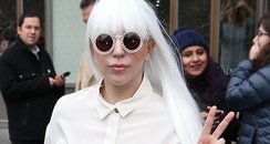 Lady Gaga wearing a white suit wiht a long whiite 