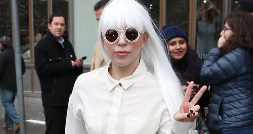 Lady Gaga wearing a white suit wiht a long whiite 