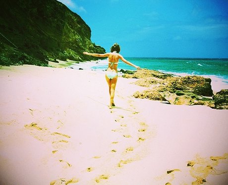 Taylor Swift on a beach looking for easter eggs