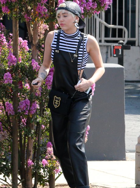 Miley Cyrus wearing leather dungarees
