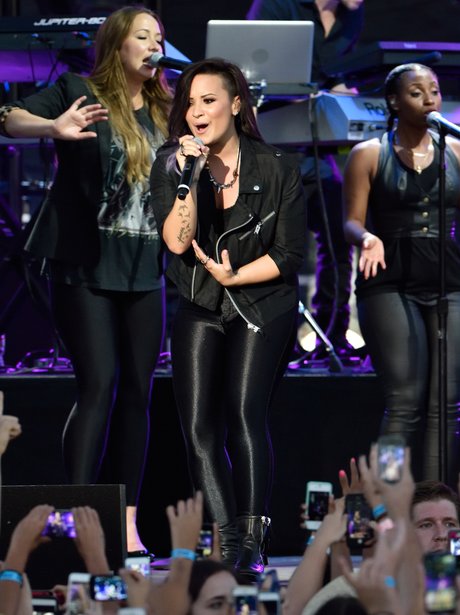 Demi Lovato wearing a black catsuit on stage