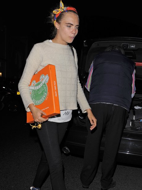 Cara Delevingne carrying a pizza