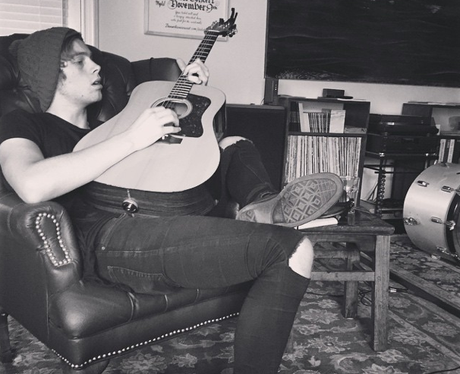Luke form 5SOS paying a guitar