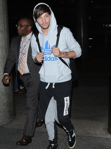 Louis Tomlinson wearing a tracksuit at the airport