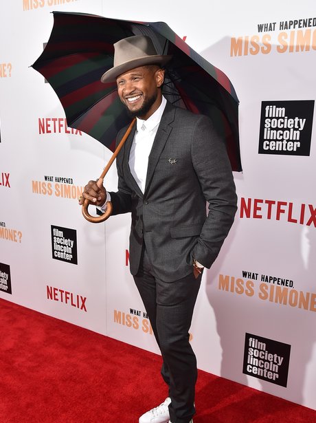 Usher hols an Umbrella on the red carpet