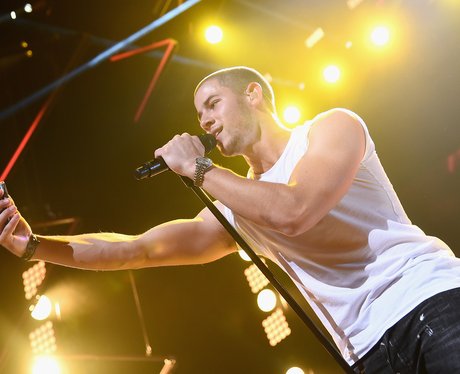 Nick Jonas taking a selfie on stage
