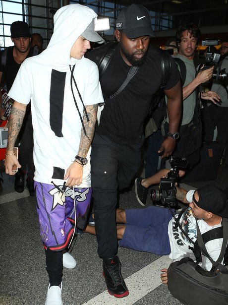 Justin Bieber looking at a paparazzi who's fallen