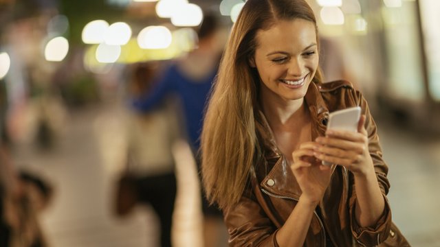 Woman using mobile phone and smiling