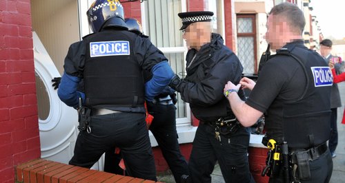 Police  break down door in drugs raids
