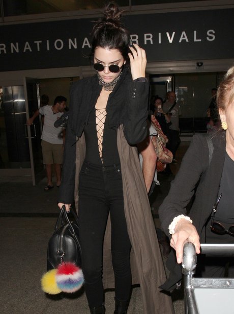 Kendall Jenner lands back in LA in plunging bodysu