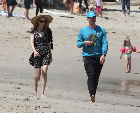 Heather Graham and Chris Martin walking on the bea